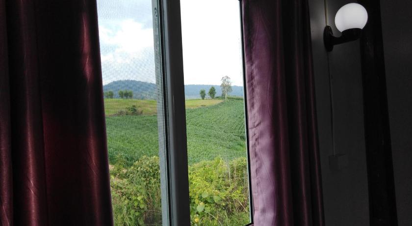 a view through a window of a house with trees, Khao Kho Flora in Khao Kho