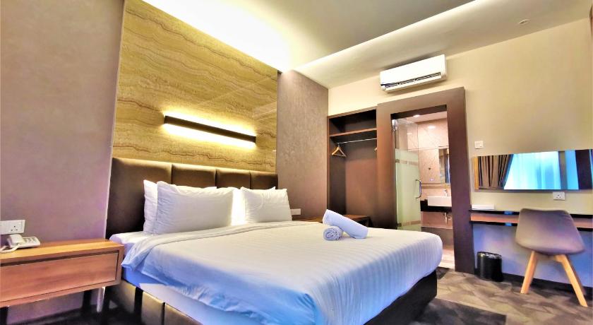 a hotel room with a large bed and a television, Prestigo Hotel in Johor Bahru