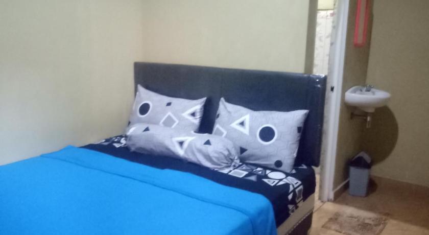 a bed in a room with a blue wall, Yanto homestay anugrah tumpak sewu in Malang