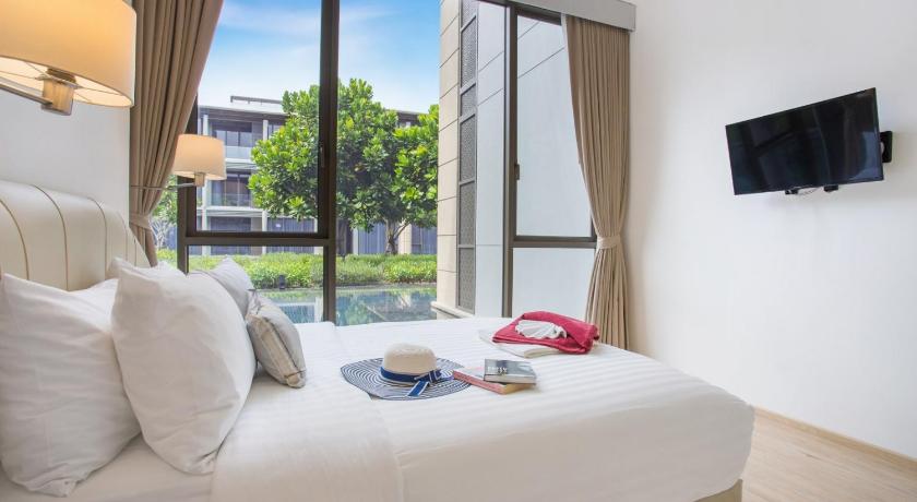 a hotel room with a bed and a television, Luxury Oceanfront_pool access apartment in Phuket