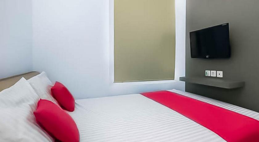 a hotel room with a bed and a television, RedDoorz near Stasiun Lawang in Malang