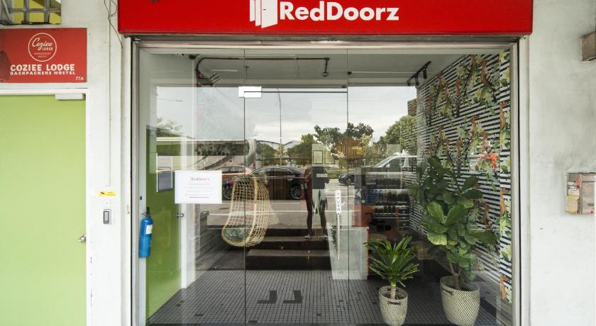 a store front with a door open and a sign on the door, RedDoorz Hostel @ Kallang MRT (SG Clean Certified) in Singapore
