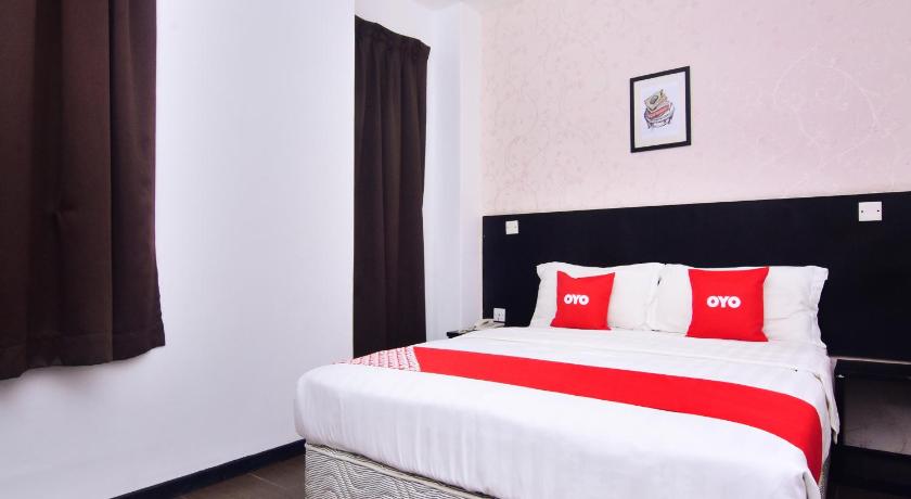 a white bed sitting in a bedroom next to a window, OYO 43959 Astana Hotel in Tawau