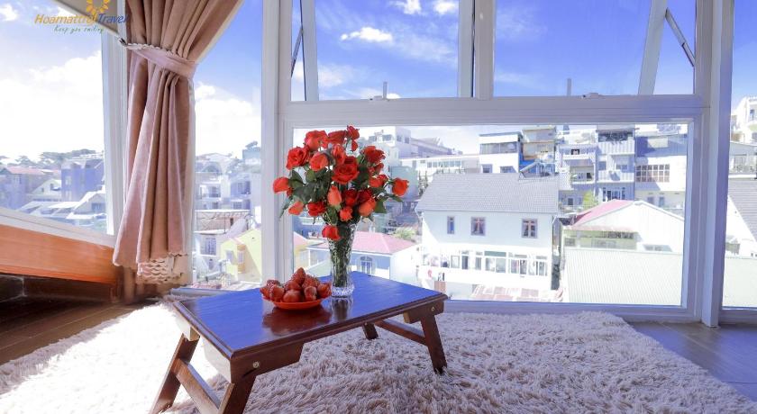 a vase with flowers on a table in front of a window, Nang Chieu Hotel Đa Lat in Dalat