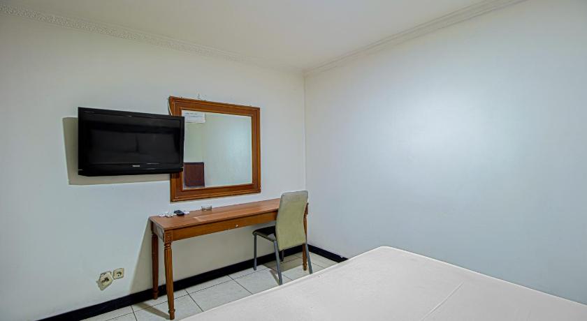 a hotel room with a bed and a television, Ende Elok Hotel in Jakarta