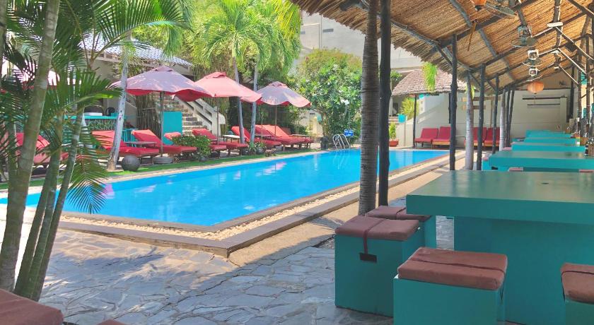 a patio area with tables, chairs and umbrellas, Mui Ne Hills Budget Hotel in Phan Thiet