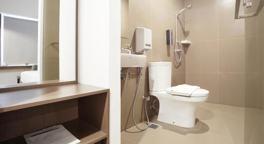 a white toilet sitting in a bathroom next to a sink, Malioboro Prime Hotel in Yogyakarta