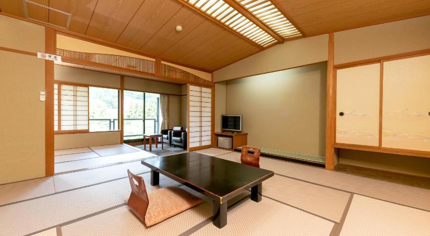 a living room filled with furniture and a large window, Itoen Hotel New Sakura in Nikko