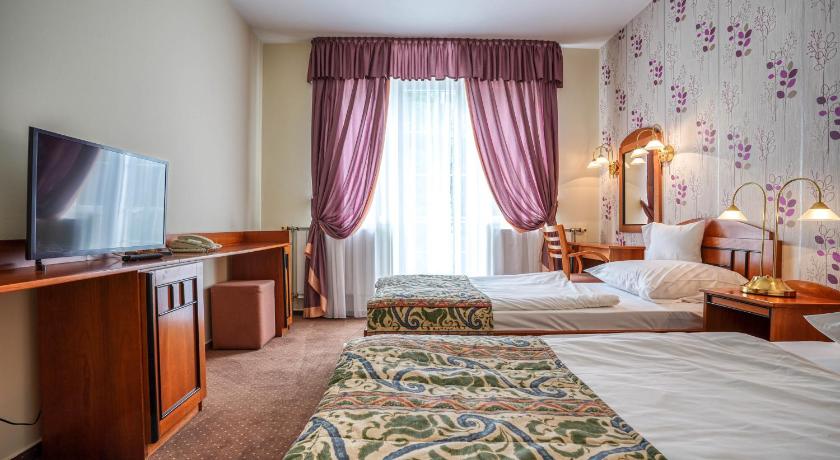 a hotel room with a bed and a television, Hotel Erzsebet in Hévíz