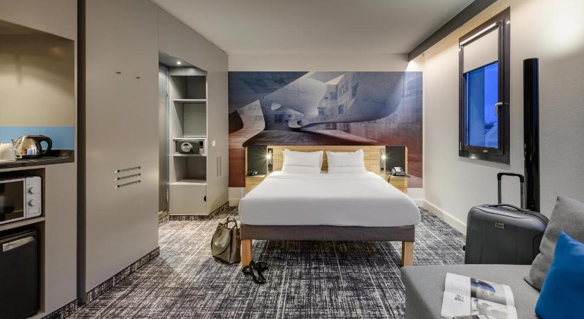 a hotel room with a large bed and a television, Novotel Suites Berlin City Potsdamer Platz in Berlin