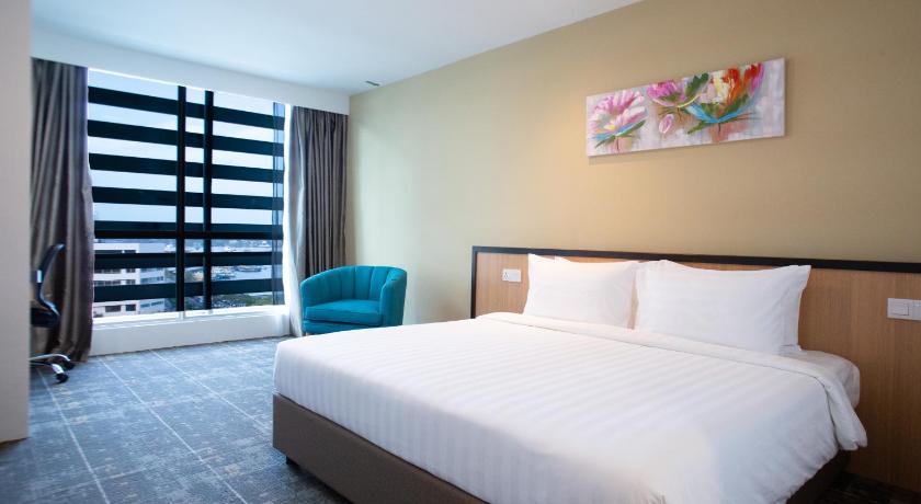 a bedroom with a large bed and a large window, Hotel 7 Suria in Kota Kinabalu