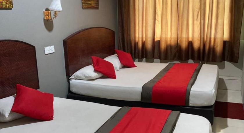 a hotel room with two beds and two lamps, Stada Hotel in Kota Bharu