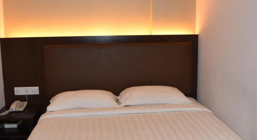 a hotel room with a bed and a lamp, Sunrise Hotel in Kuala Lumpur