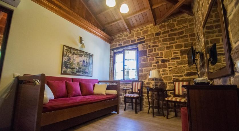 a living room filled with furniture and a fireplace, Archontiko Riziko in Chios