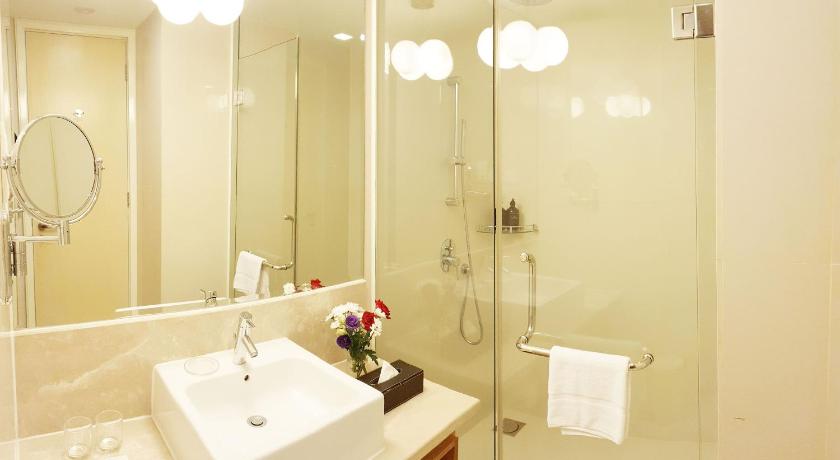 a bathroom with a shower, sink, and mirror, Cormar Suites in Kuala Lumpur