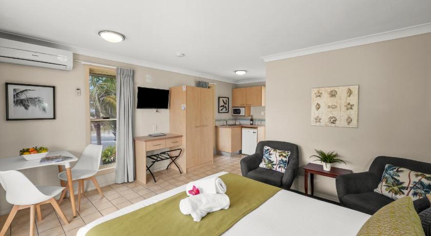 a living room with a bed, couch, chair and a tv, Yamba Sun Motel in Yamba