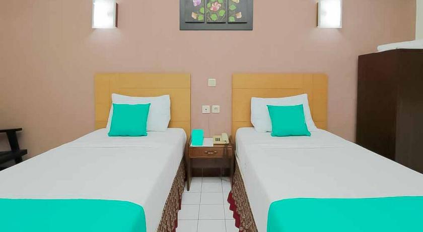 two twin beds in a room with a blue wall, Hotel Lestari Near Lippo Plaza Mall Jember in Jember