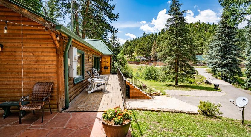 a wooden bench sitting in front of a forest, Colorado Bear Creek Cabins in Evergreen (CO)