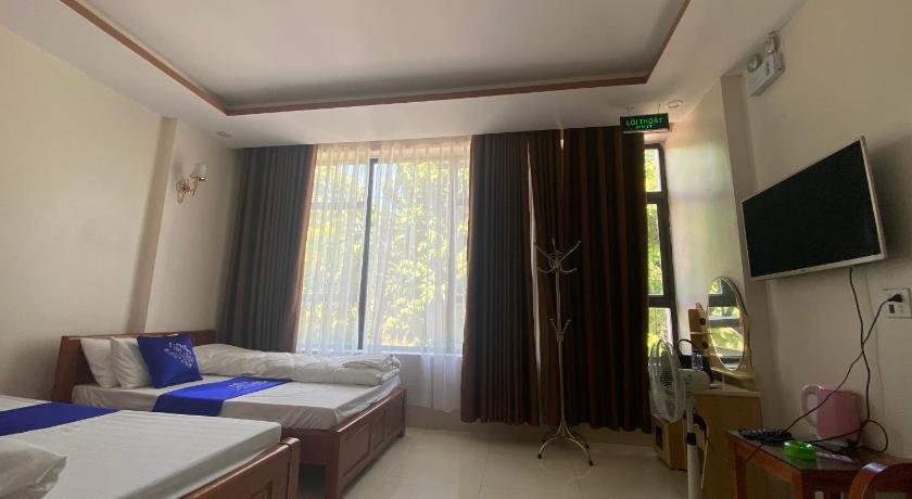 a room with a bed, a television, and a window, Van Anh Motel in Lao Cai City