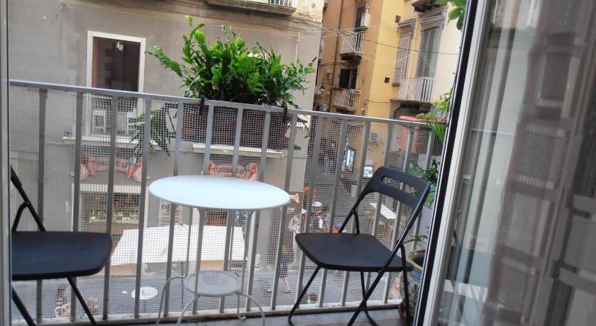 a patio area with chairs, tables and umbrellas, La Residenza Napoli Chiaia short let apartments Via Chiaia 82 in Naples