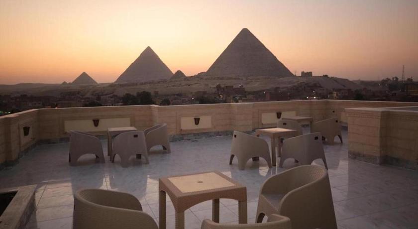 an outdoor dining area with tables and chairs, The Lotus Guest House - 3 Pyramids View in Giza