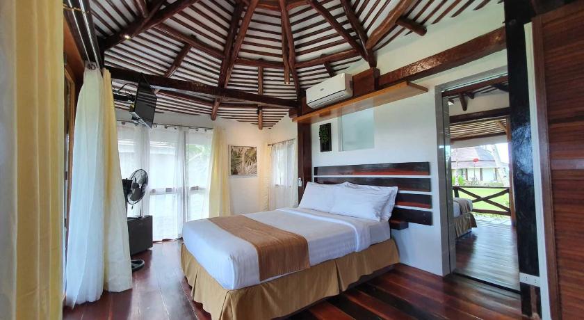 a bedroom with a bed and a window, Caluwayan Palm Island Resort and Restaurant in Marabut