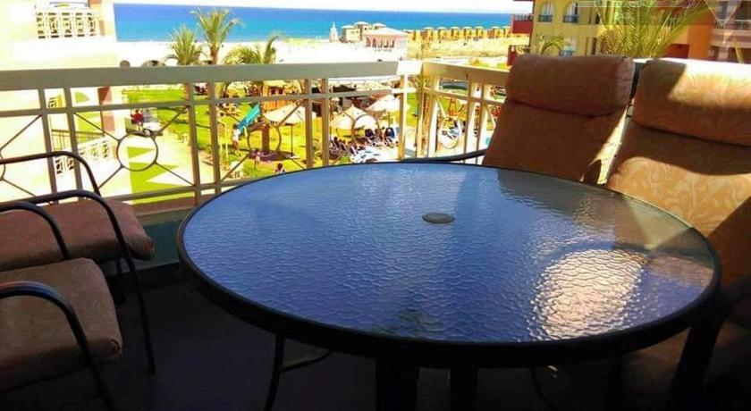 a dining room table with a blue umbrella, Sun studios in porto south beach families only in Ataqah