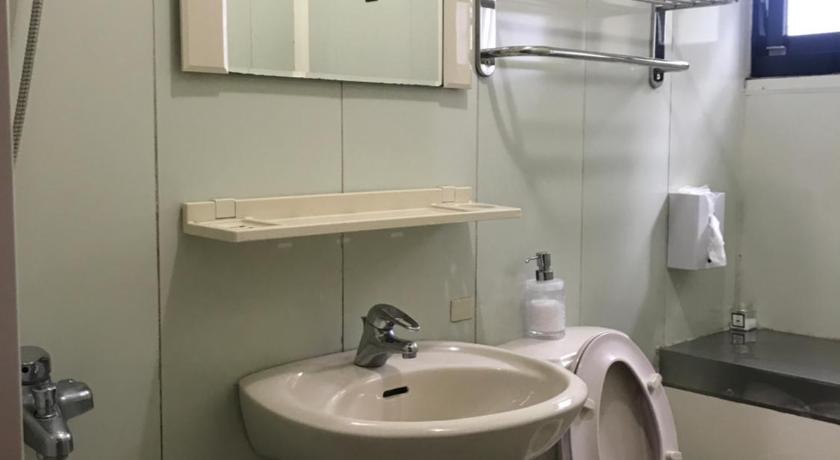 a bathroom with a sink, toilet and mirror, Lanting Yazhu B&B in Nantou