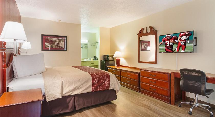 a bedroom with a bed, desk and a painting on the wall, Red Roof Inn Montgomery - Midtown in Montgomery (AL)