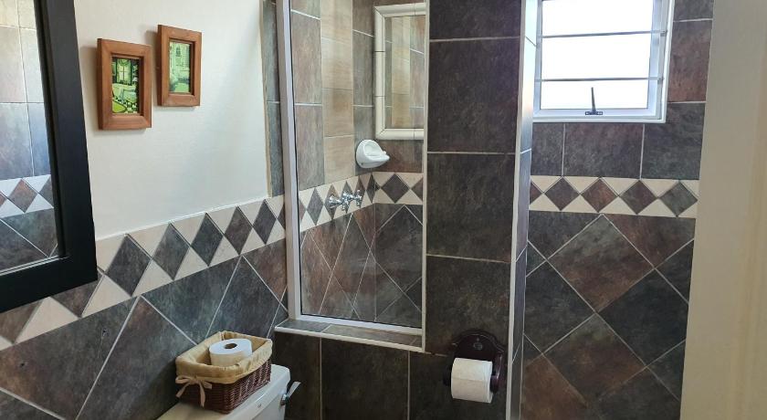 a bathroom with a toilet and a shower stall, The Lazy Lizard in Durban