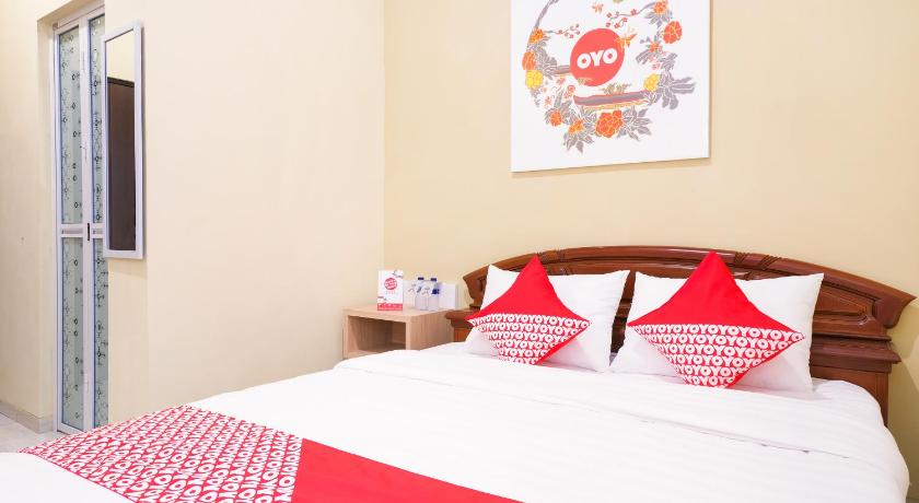 a bed room with two beds and a lamp, OYO 90033 DeHome Family in Yogyakarta