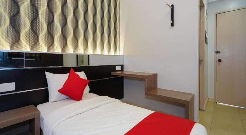 a hotel room with a bed and a desk, Super OYO 44083 Hotel Orchard Inn in Lumut