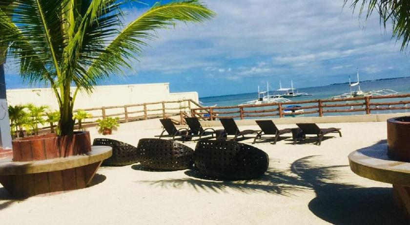 a beach area with chairs, tables and umbrellas, Palmbeach Resort & Spa in Cebu