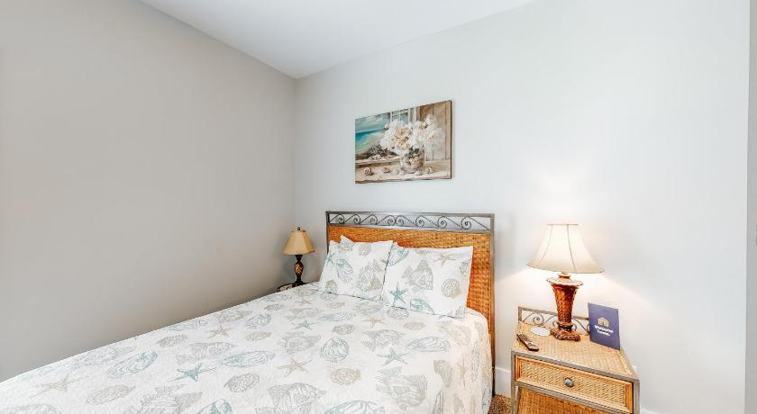 a bedroom with a bed and a lamp, Barefoot Cottages #B16 in Port Saint Joe