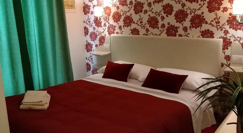a bedroom with a red and white bedspread, Il Giglio Verde in Porto Sant'Elpidio