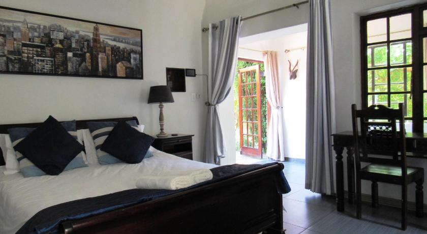 a bedroom with a bed and a window, House on York in Johannesburg