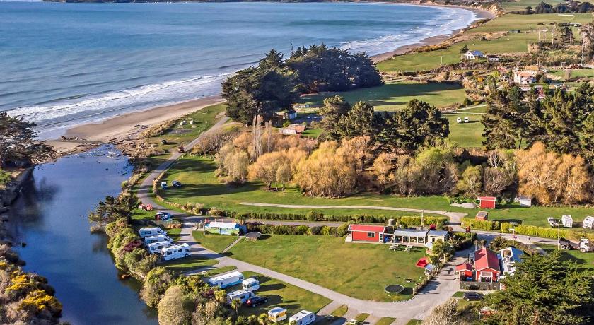 a scenic view of a beach with boats and trees, Moeraki Boulders Holiday Park & Motel in Hampden