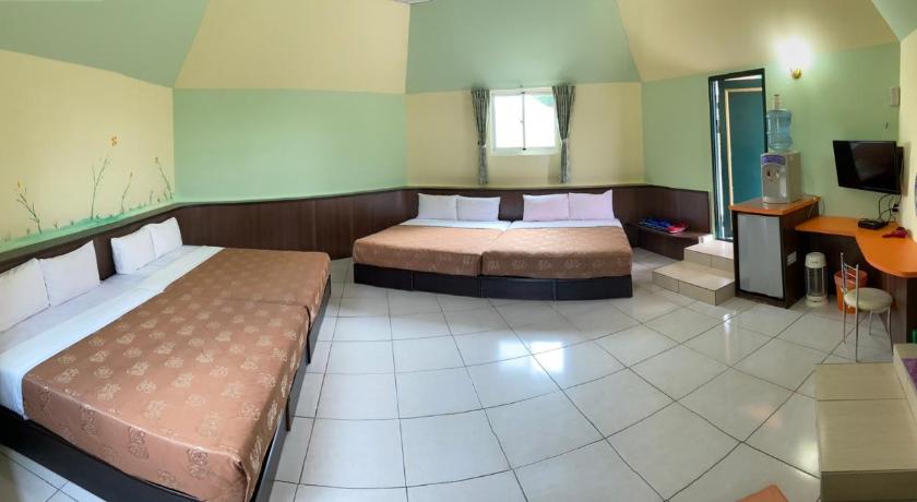 a hotel room with two beds and a table, J Lin Hostel in Kenting