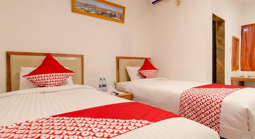 a hotel room with two beds and two lamps, OYO 2410 Intan Hotel in Kutacane