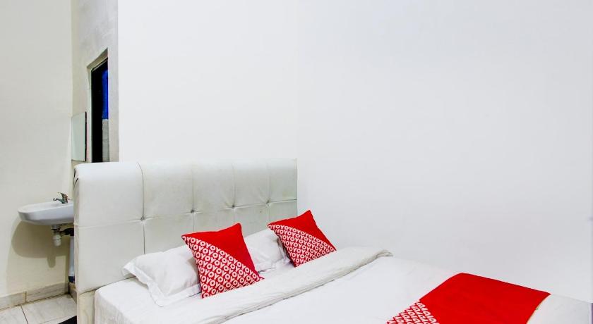 a bedroom with a white bedspread and white pillows, OYO 2965 Silvia Homestay in Kupang