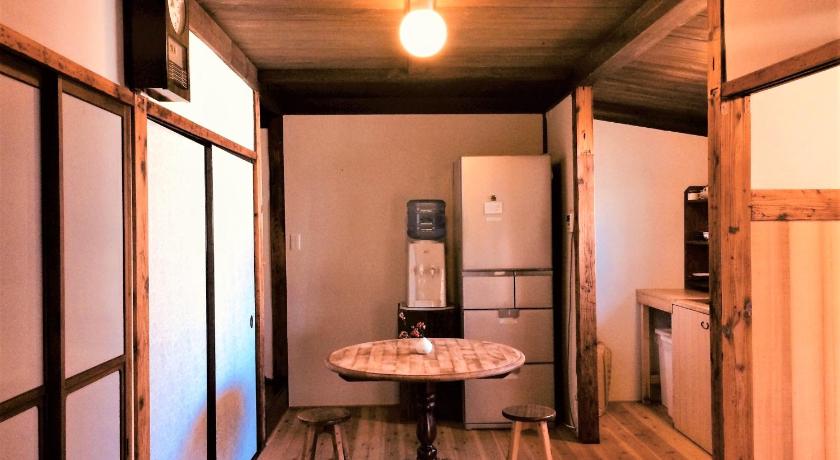 a kitchen with a table and a refrigerator, Guest House Kobako in Kyoto