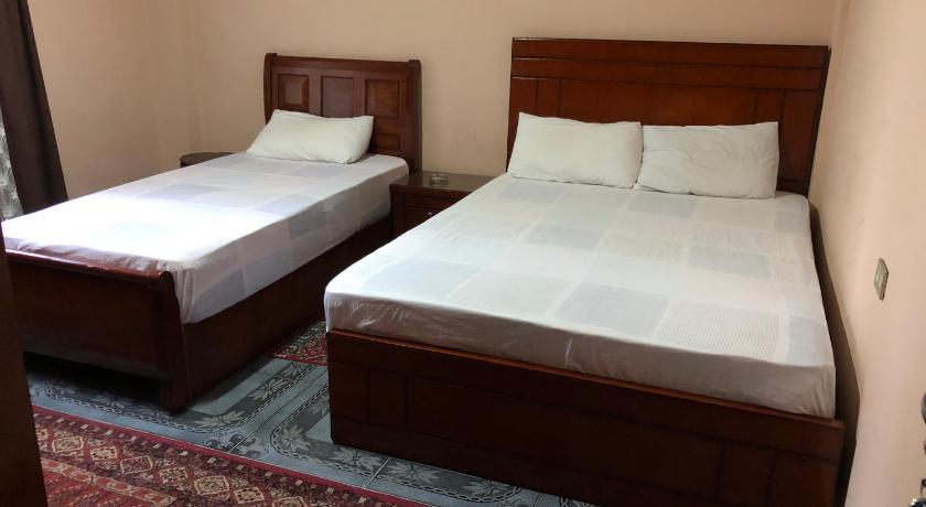two beds in a room with a white bedspread, Caesar House in Alexandria