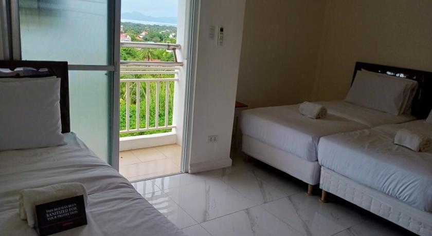 a bedroom with a bed and a window, Centtro Residences in Laguna