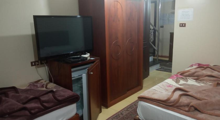 a bedroom with a bed and a television, Al Maghraby Hotel in Alexandria