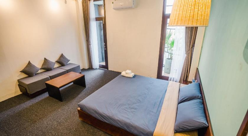 a bedroom with a bed and a desk, The Garden Hotel and Apartment in Da Nang