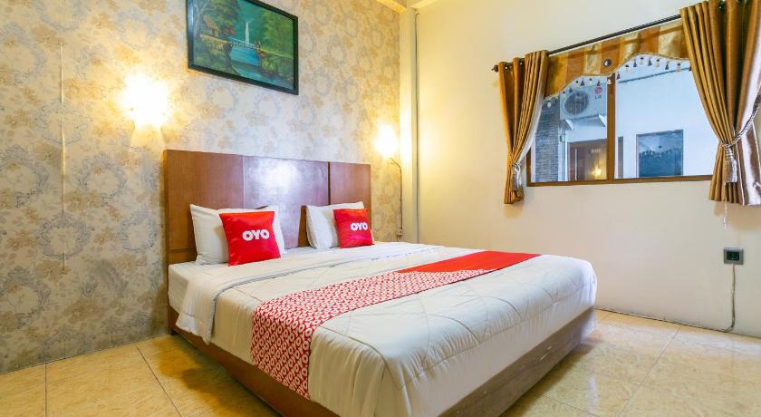 a hotel room with a large bed and a large window, OYO 3344 Kanca Hotel in Banjarmasin
