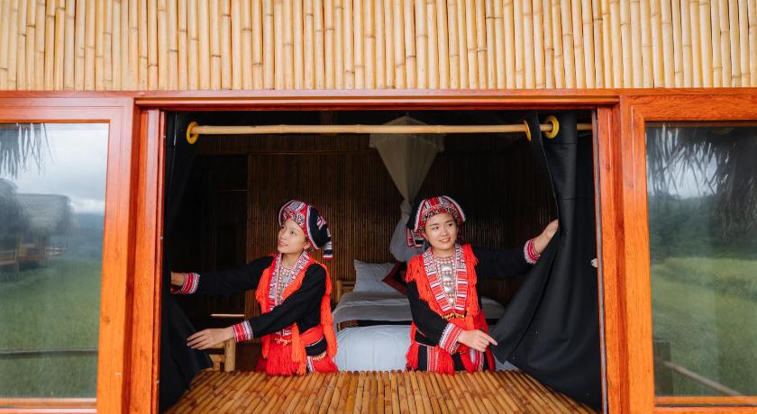 two women sitting in front of a wooden cabin, Hoang Su Phi Lodge in Ha Giang