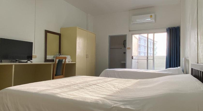 a hotel room with a white bed and white walls, Monta Apartment in Chonburi