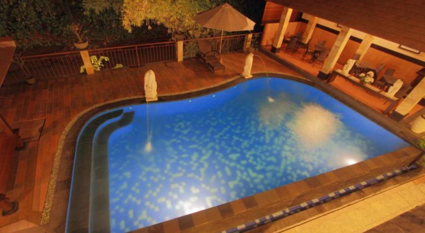 a bath tub sitting next to a pool of water, Hotel Puri Nusa Indah                                                                            in Bali