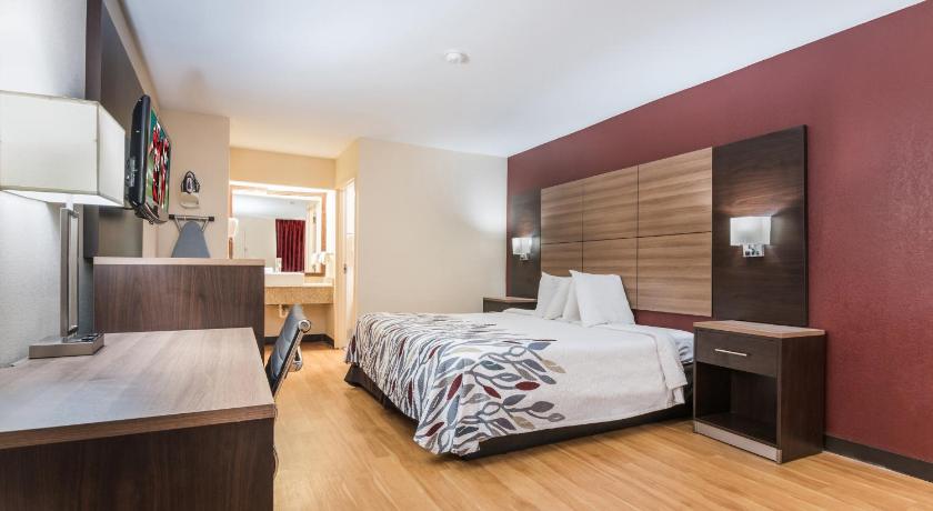 a hotel room with a bed and a desk, Red Roof Inn Texarkana in Texarkana (AR)